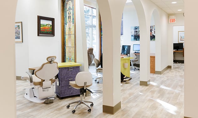 A view of the clinical area showing treatment chairs positioned under elegant white architectural arches.