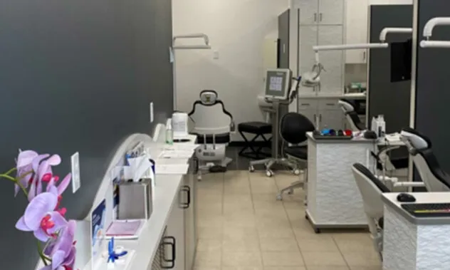 A view of a modern, clinical orthodontic treatment area with specialized chairs and equipment.