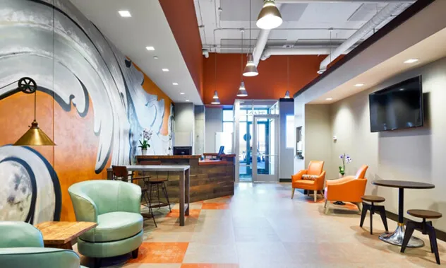 A view of the office interior showing the reception desk, seating area, and a hallway leading to treatment rooms.
