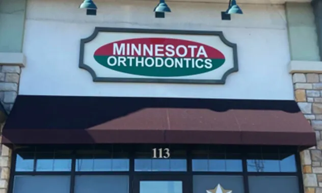 A close-up of the office's exterior signage above the entrance, featuring the practice's logo on a brown awning.