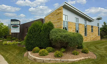 daytime shot of a contemporary stone and tan office building with professional landscaping and a monument sign for Minnesota Orthodontics.