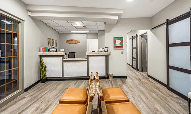 A perspective shot from the lobby looking down a hallway toward the reception desk and clinical areas.